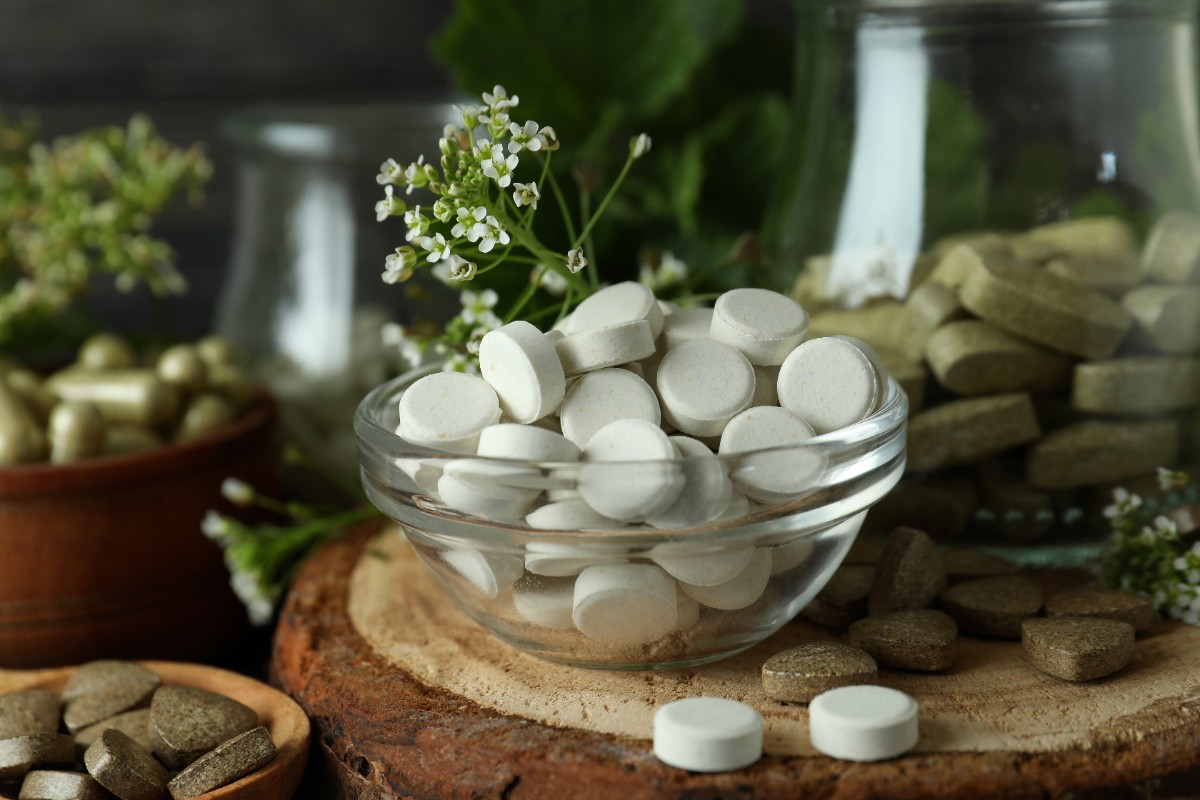 Gélules et flacons de compléments alimentaires disposés sur une table, sans apport calorique visible