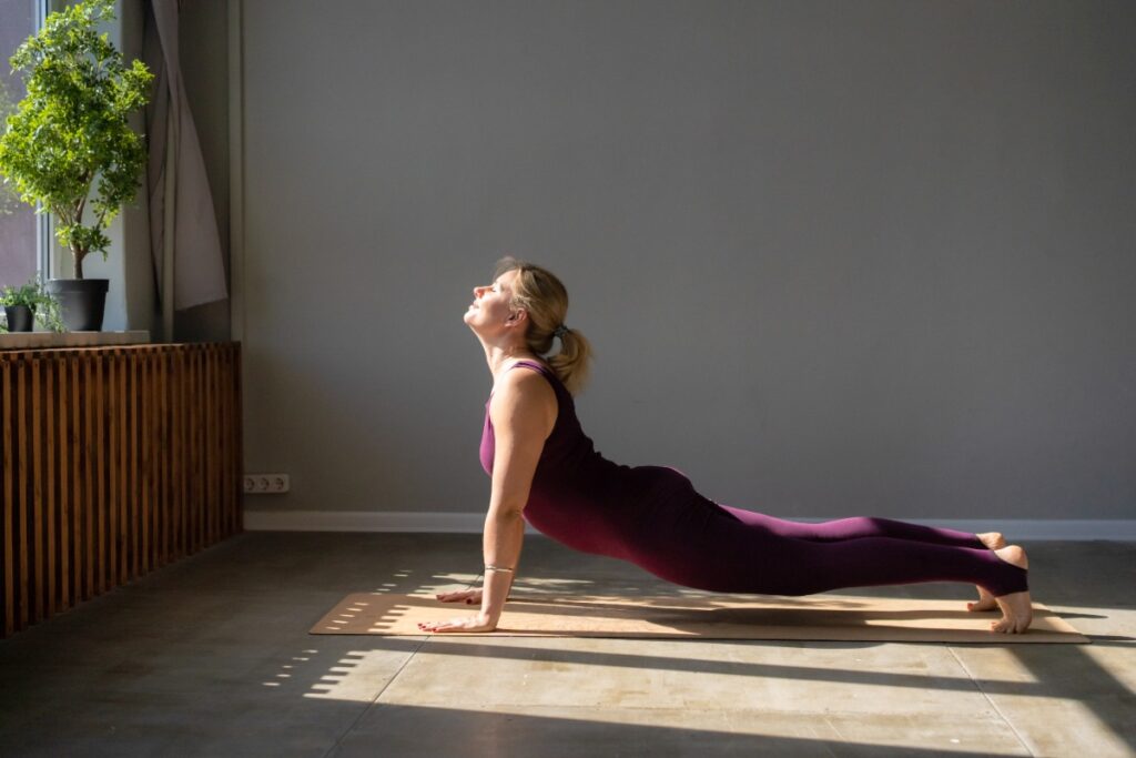Une femme qui pratique du yoga Hatha Flow à la maison
