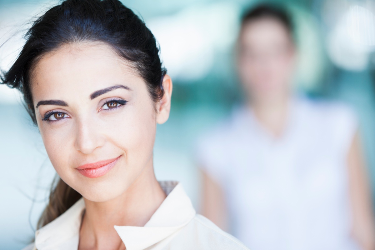 Une femme souriante en chemise blanche