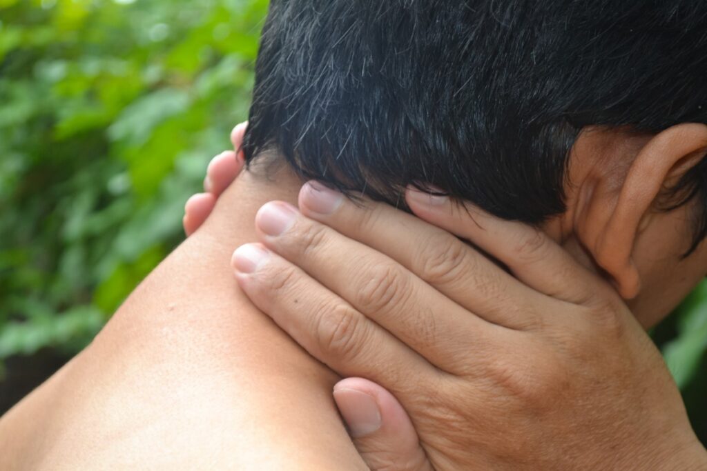 Un homme souffrant qui tient son cou