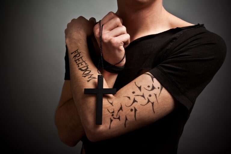 Un jeune homme en vêtement nior ayant un tatouage sur le bras