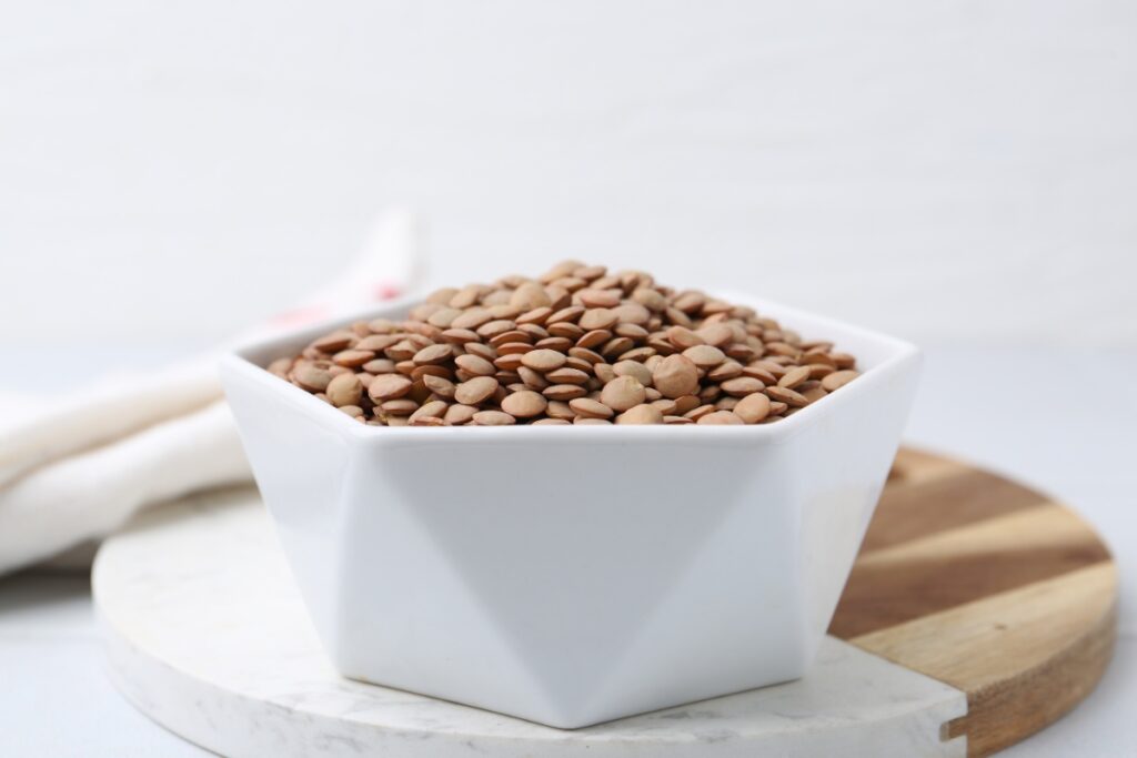 Un bol rempli de lentilles sur une planche à découper