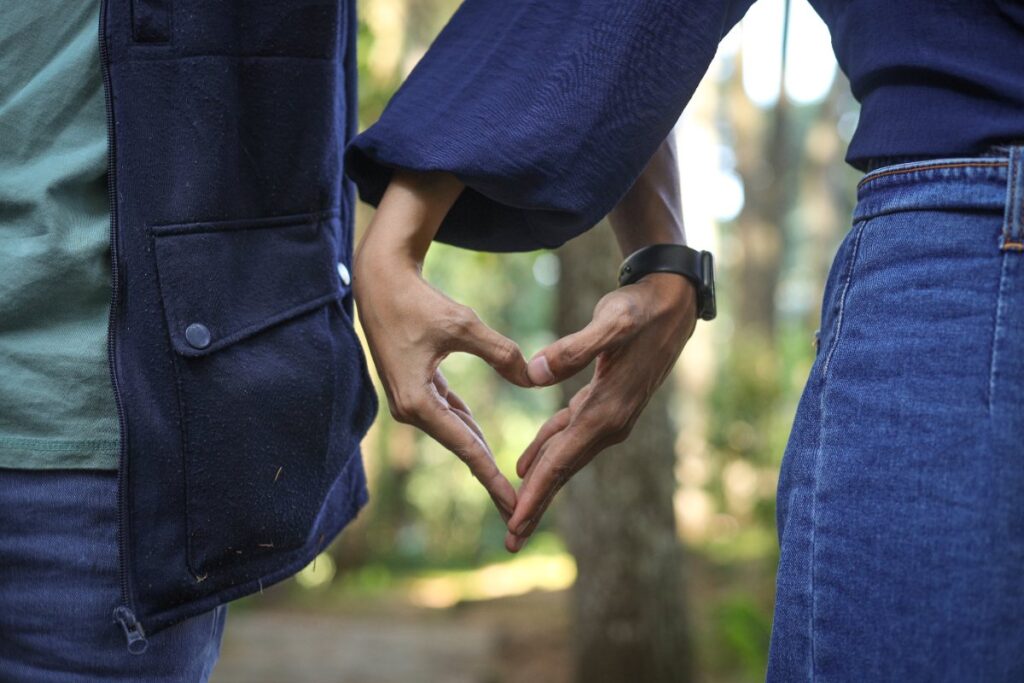 Un couple romantique formant un coeur avec leur main