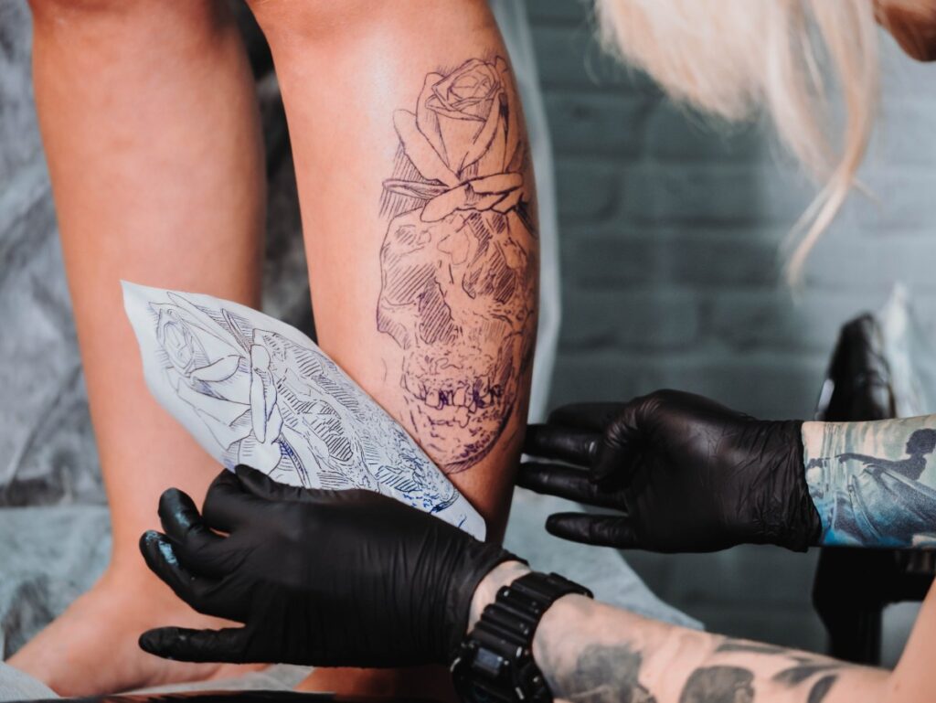Une personne qui se fait tatouer la jambe