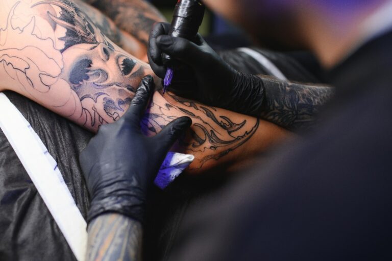 Une personne réalisant du tatouage sur le bras