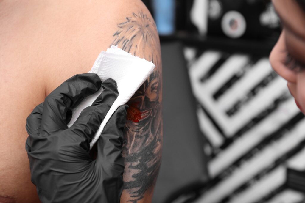 Un professionnel qui nettoie le tatouage d'une personne