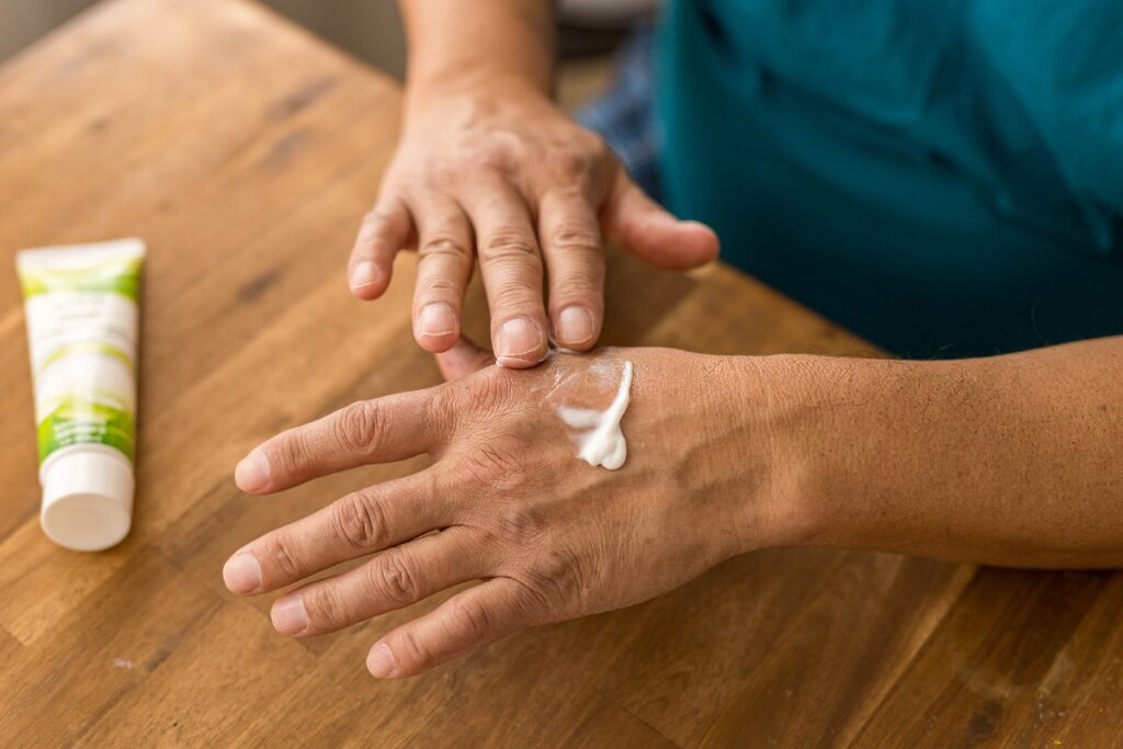 Un adulte appliquant de la crème sur la peau