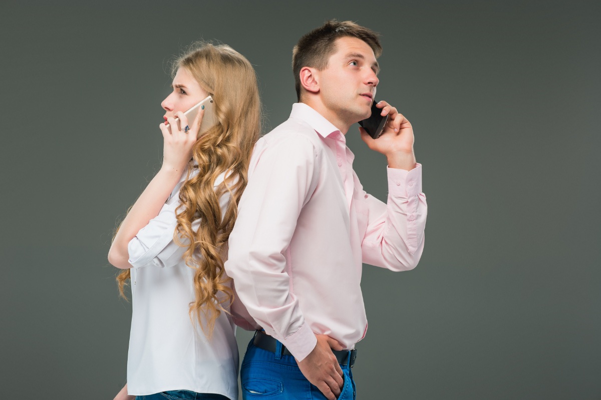 Un couple au téléphone se tournant le dos