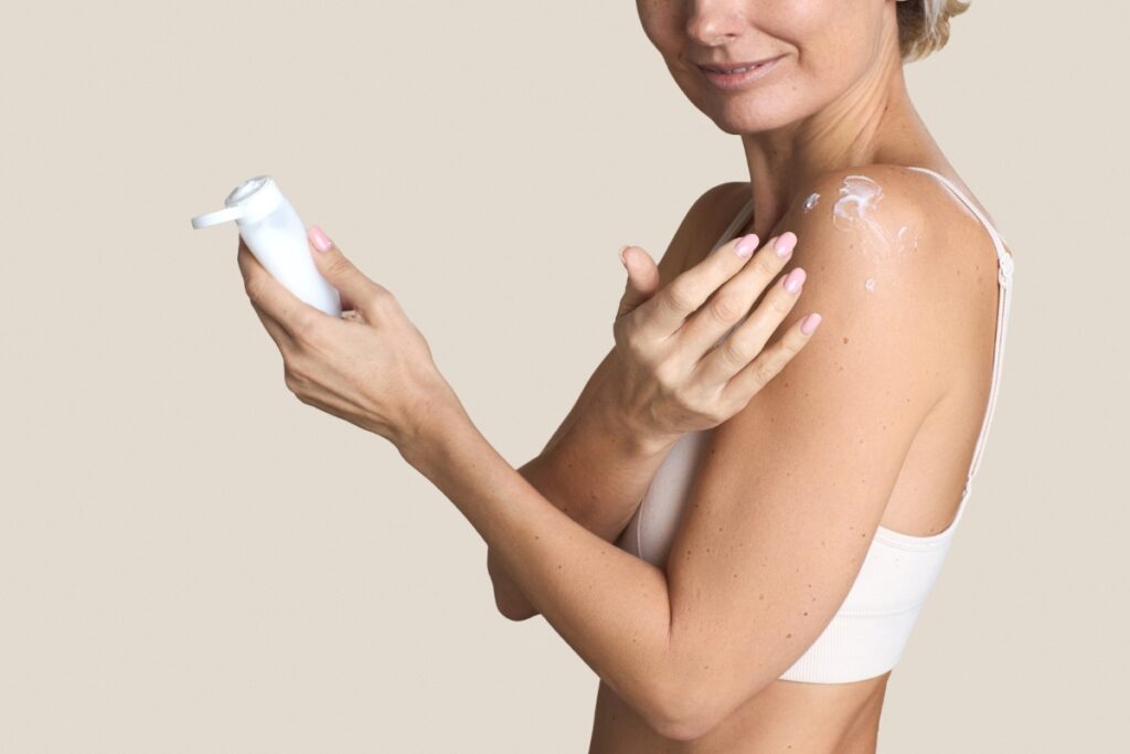 Une femme appliquant de la crème sur l'épaule