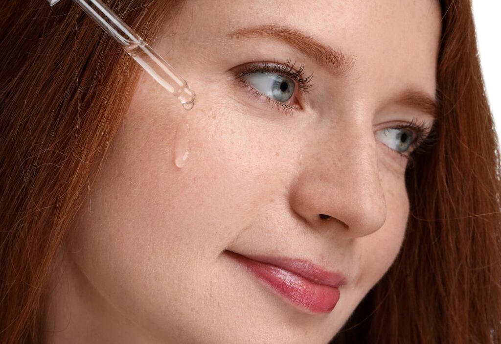 Une femme appliquant serum sur le visage