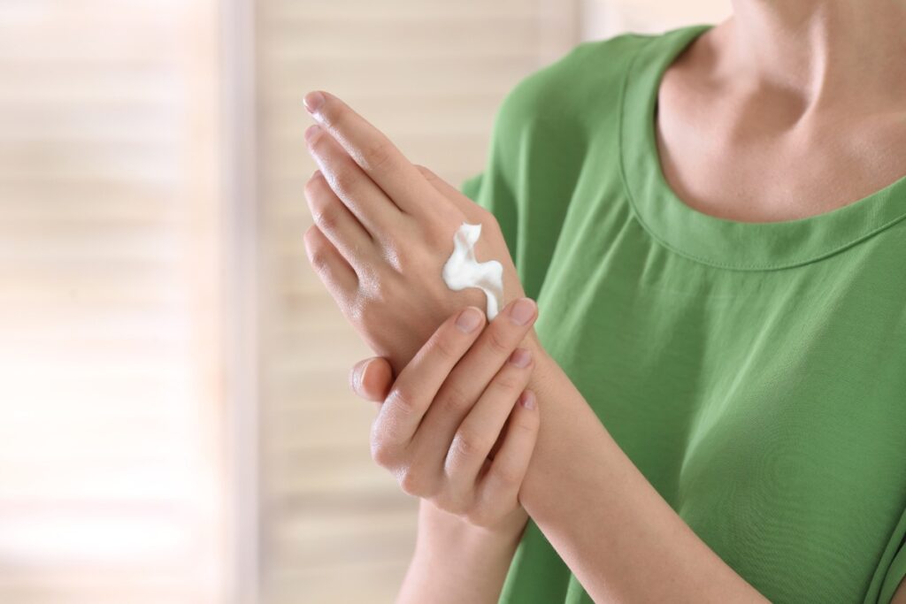 Une personne qui applique de la crème sur la main
