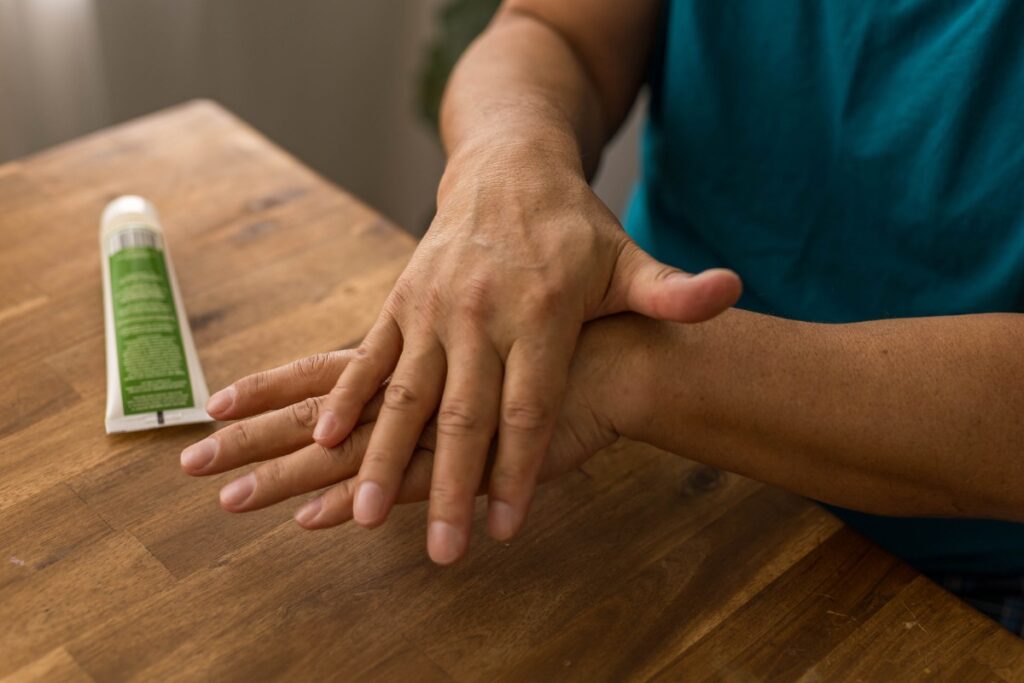 Une personne massant les mains avec de la crème