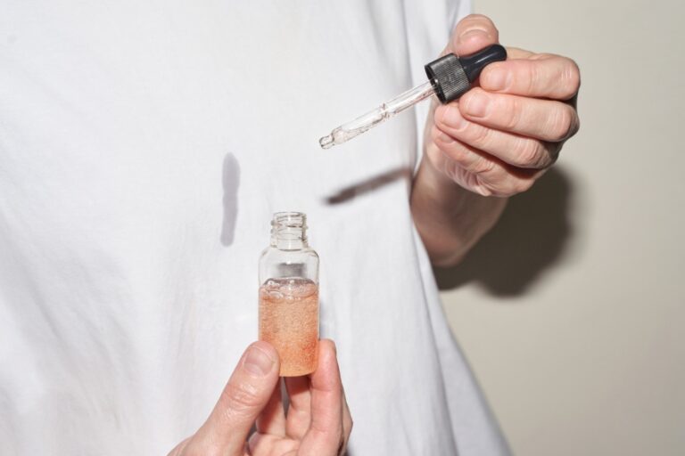 Une femme qui tient un flacon de sérum