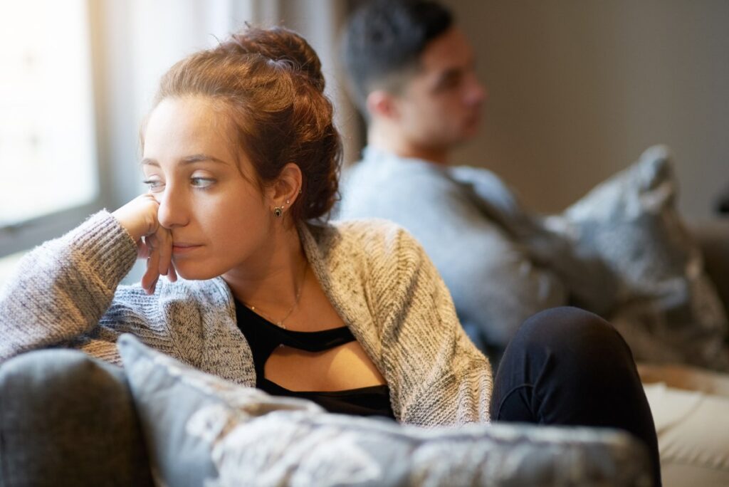 Une femme contrariée assise près de son partenaire
