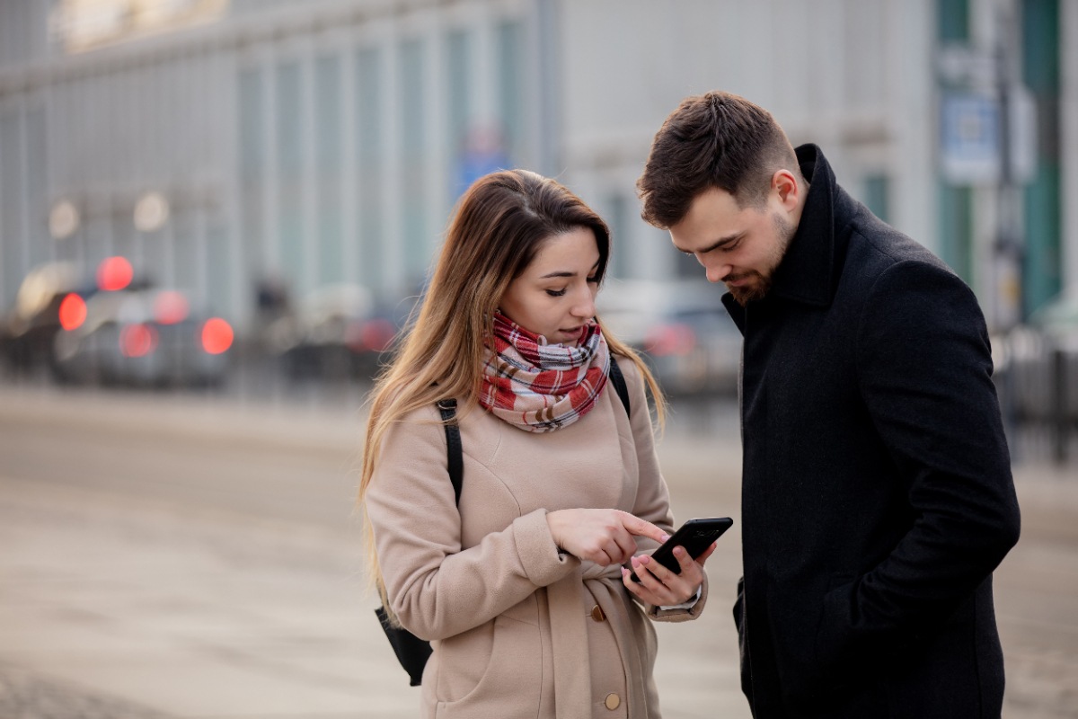 Une femme qui montre son téléphone à un homme