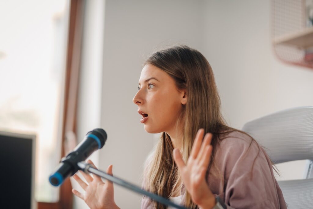 Une femme quib parle sur un micro