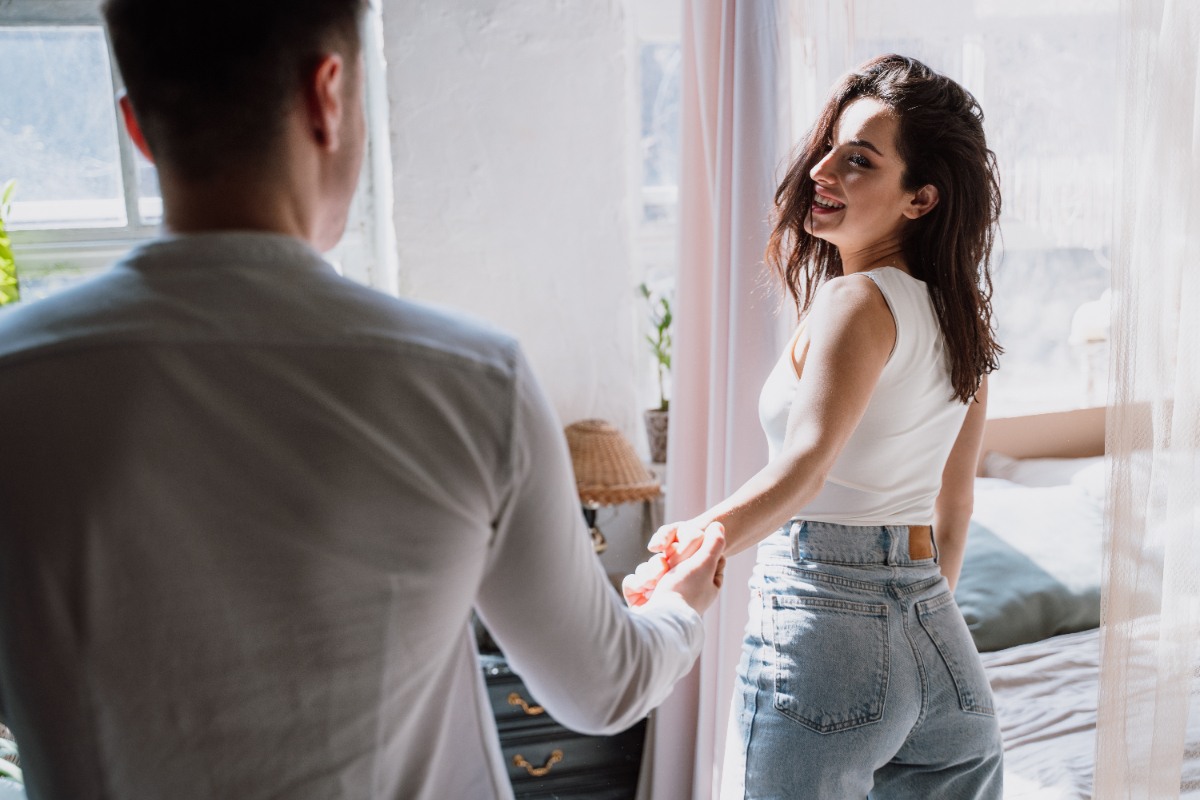 Une femme souriante tenant la main d'un homme