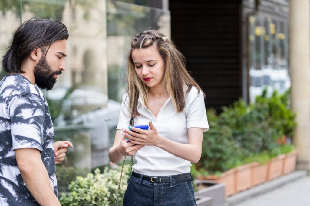 Une femme tenant son téléphone devant son homme