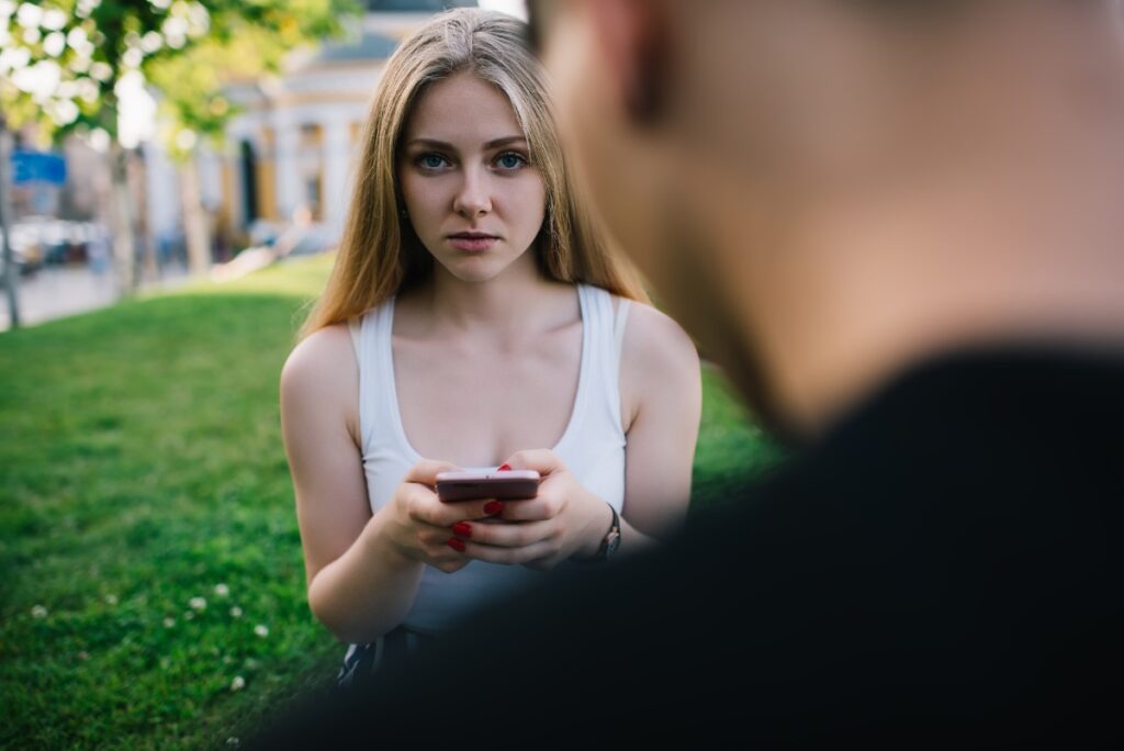 Une femme utilisant un téléphone tout en regardant un homme