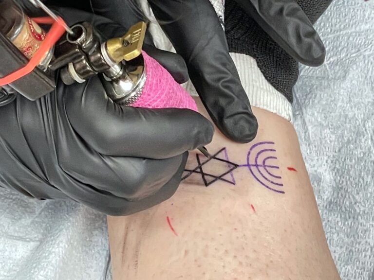 Un tatoueur réalisant une étoile sur le bras