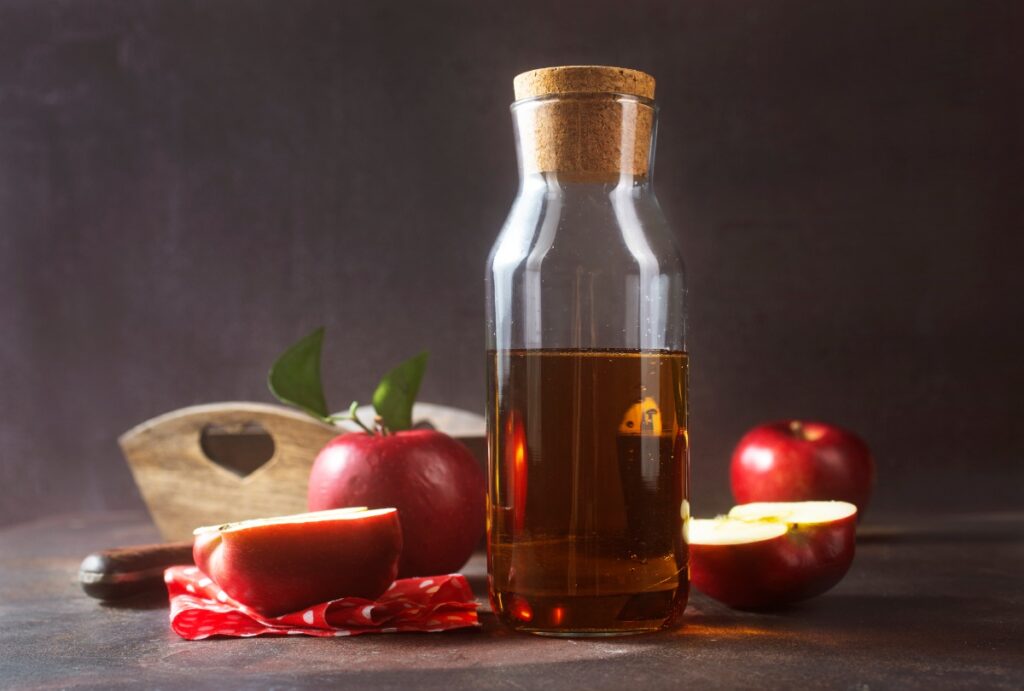 Une bouteille de vinaigre de cidre avec des pommes