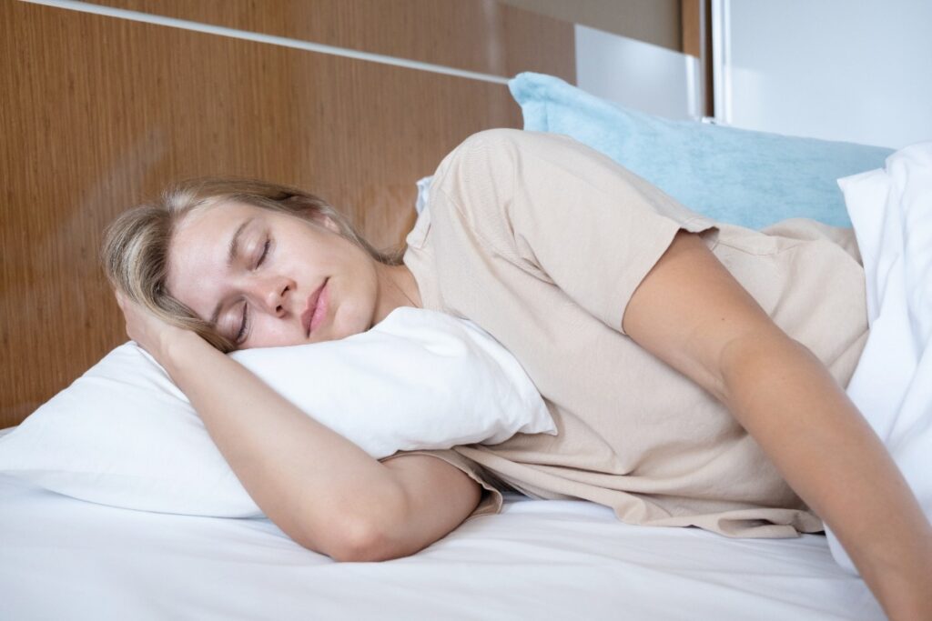 Une femme allongée sur le lit avec un oreiller