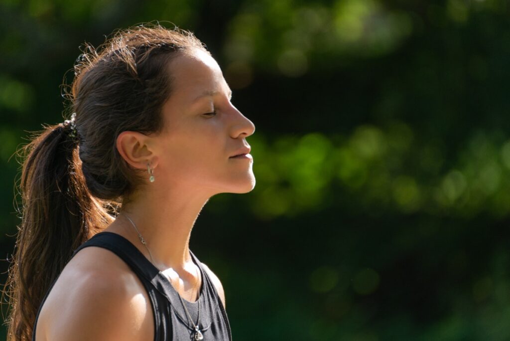 Une femme faisant un exercice de respiration à l'extérieur