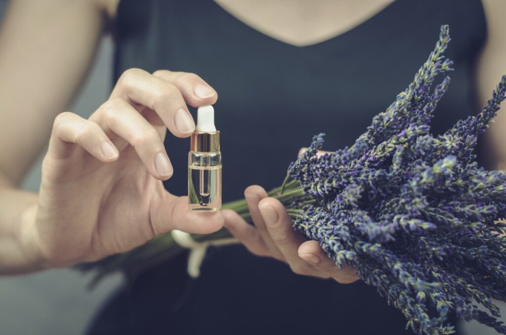 Une femme tenant un flacon d'huile essentielle de lavande