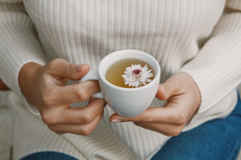 Une femme qui tient une tasse de tisane