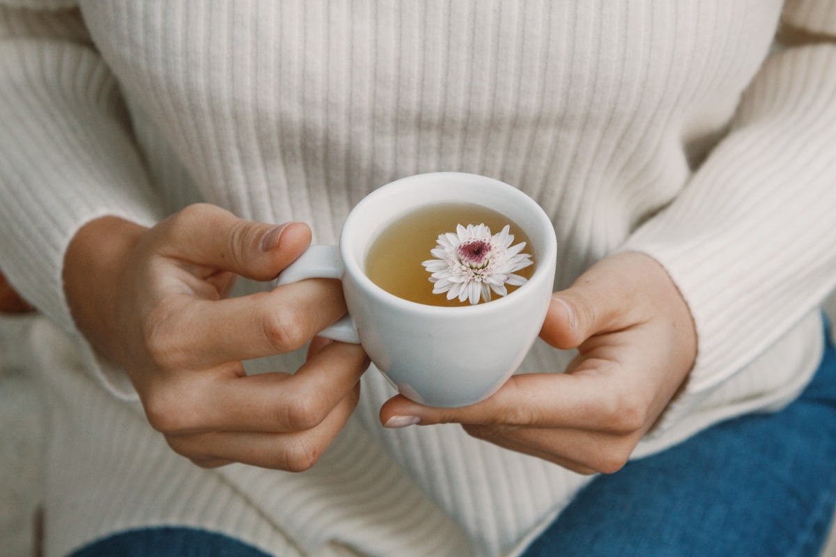 Une femme qui tient une tasse de tisane