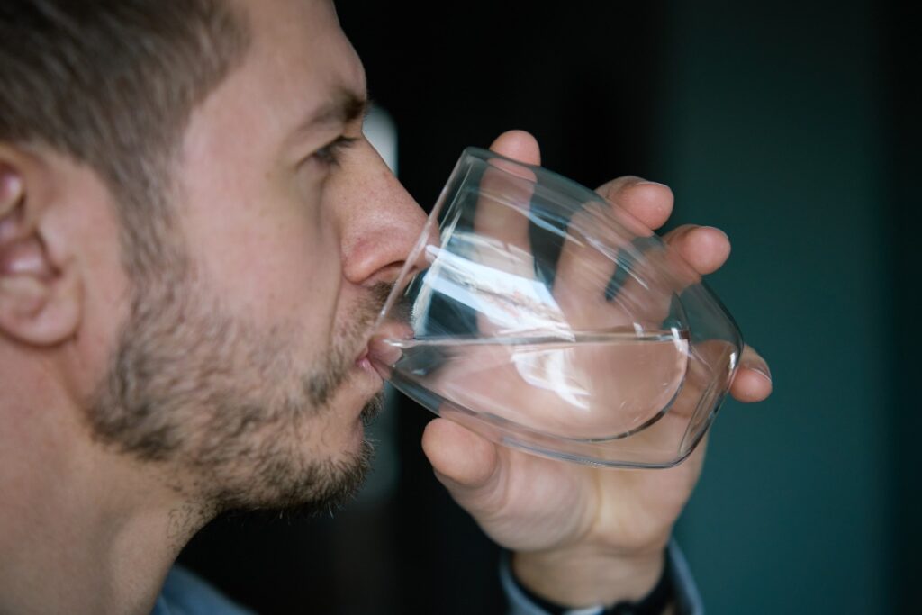 Un homme buvant un verre d'eau