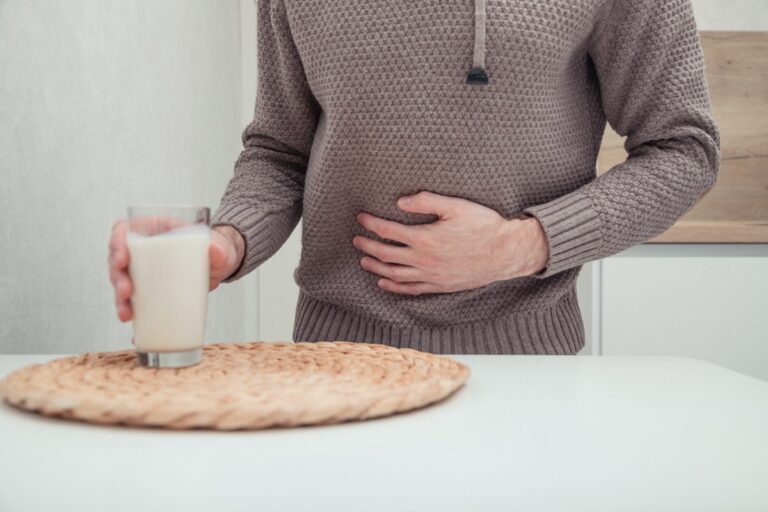 Un homme prenant un verre de lait dans la cuisine