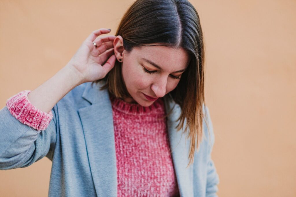 Une jeune femme qui met sa main derrière son oreille