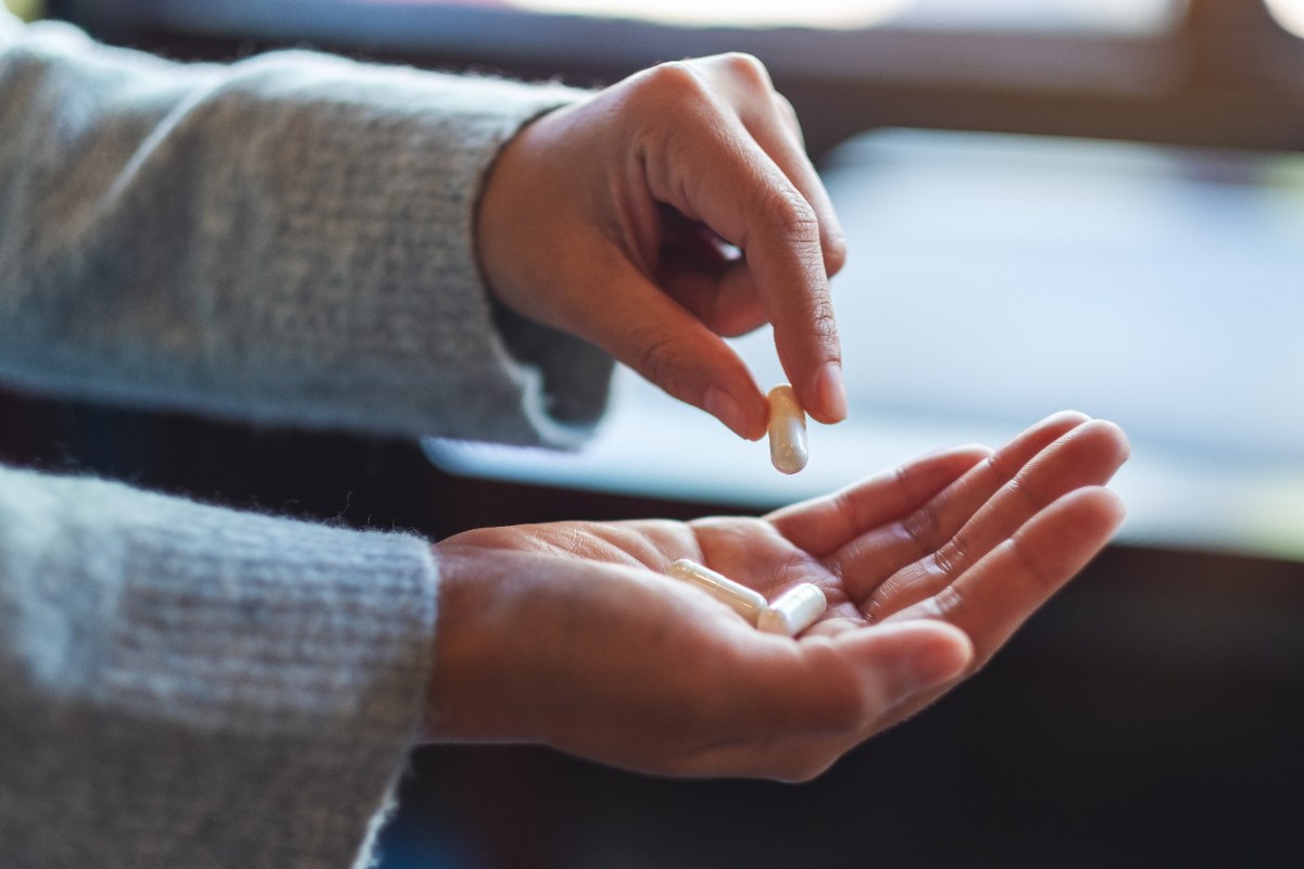 Mains tenant des pilules dans la paume