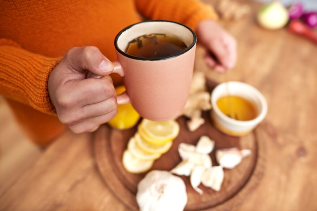 Une personne préparant du thé au gingembre avec du citron et du miel