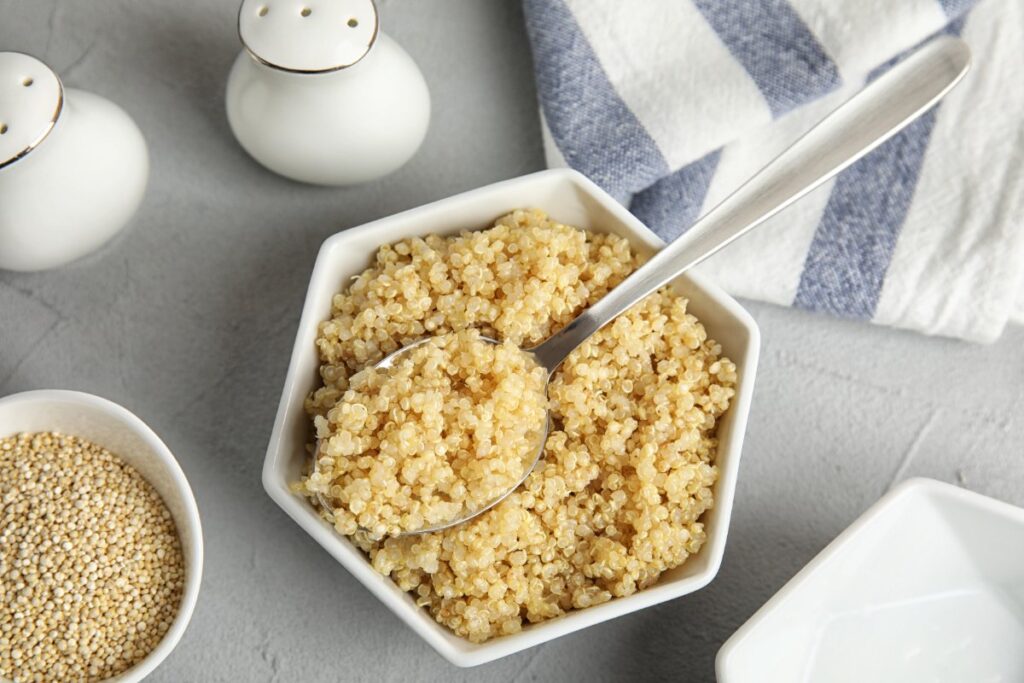 Quinoa cuit avec une cuillère dans un bol blanc