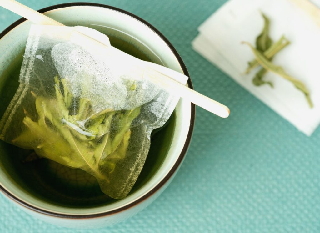 Un sachet de thé vert infusant dans un bol