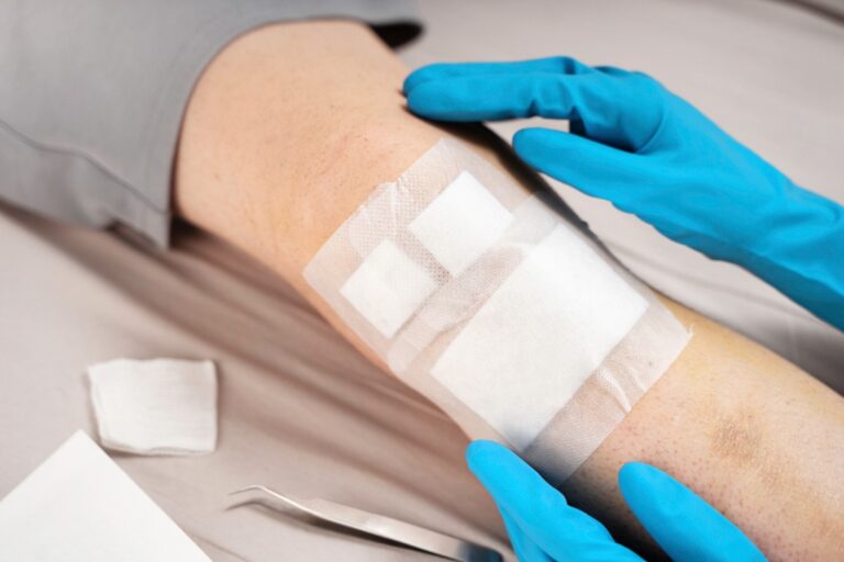 Un médecin mettant du bandage sur la jambe d'une personne